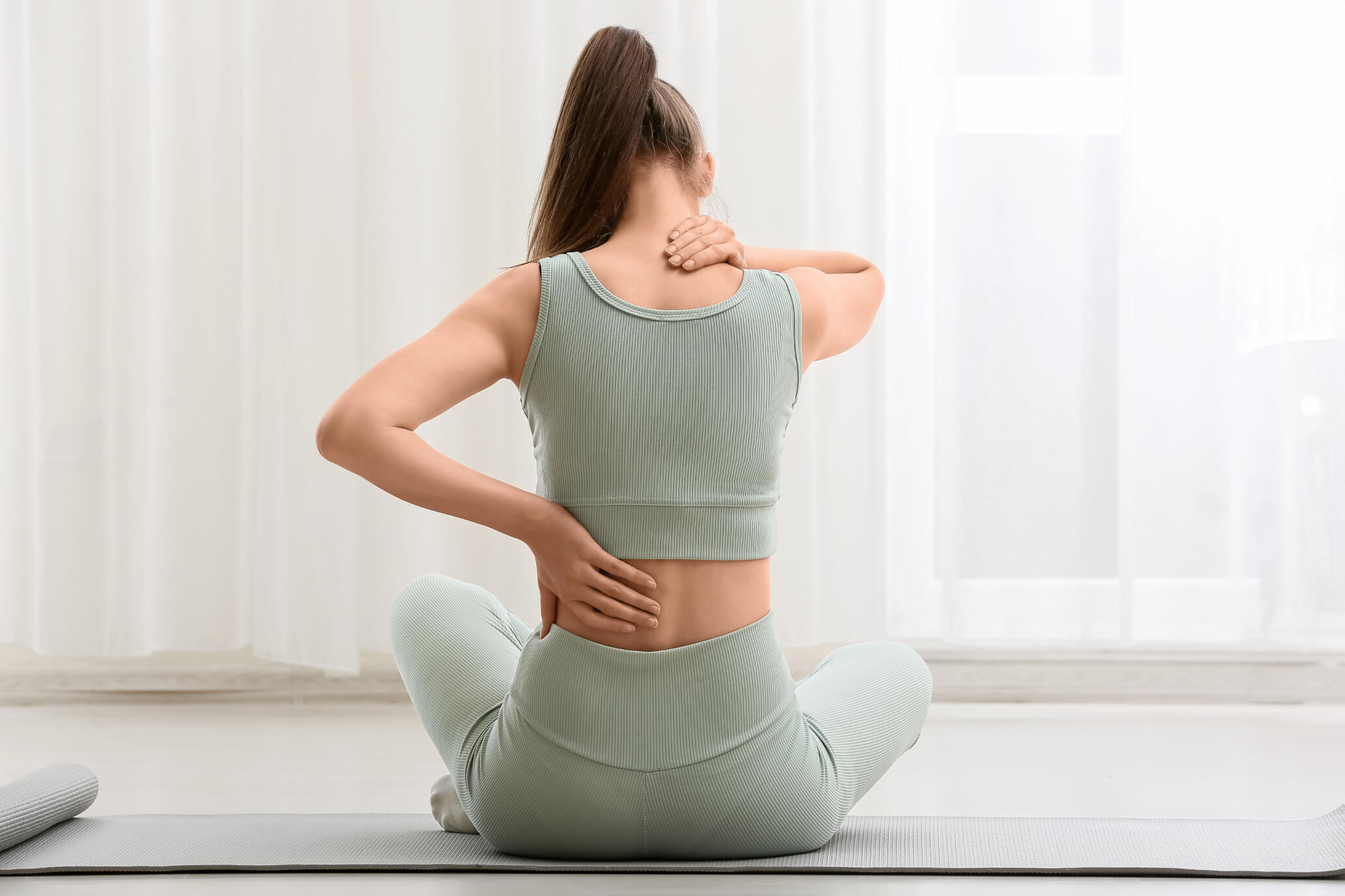 Person experiencing back and neck discomfort